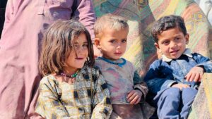 Three young children in eastern Afghanistan sitting together outside